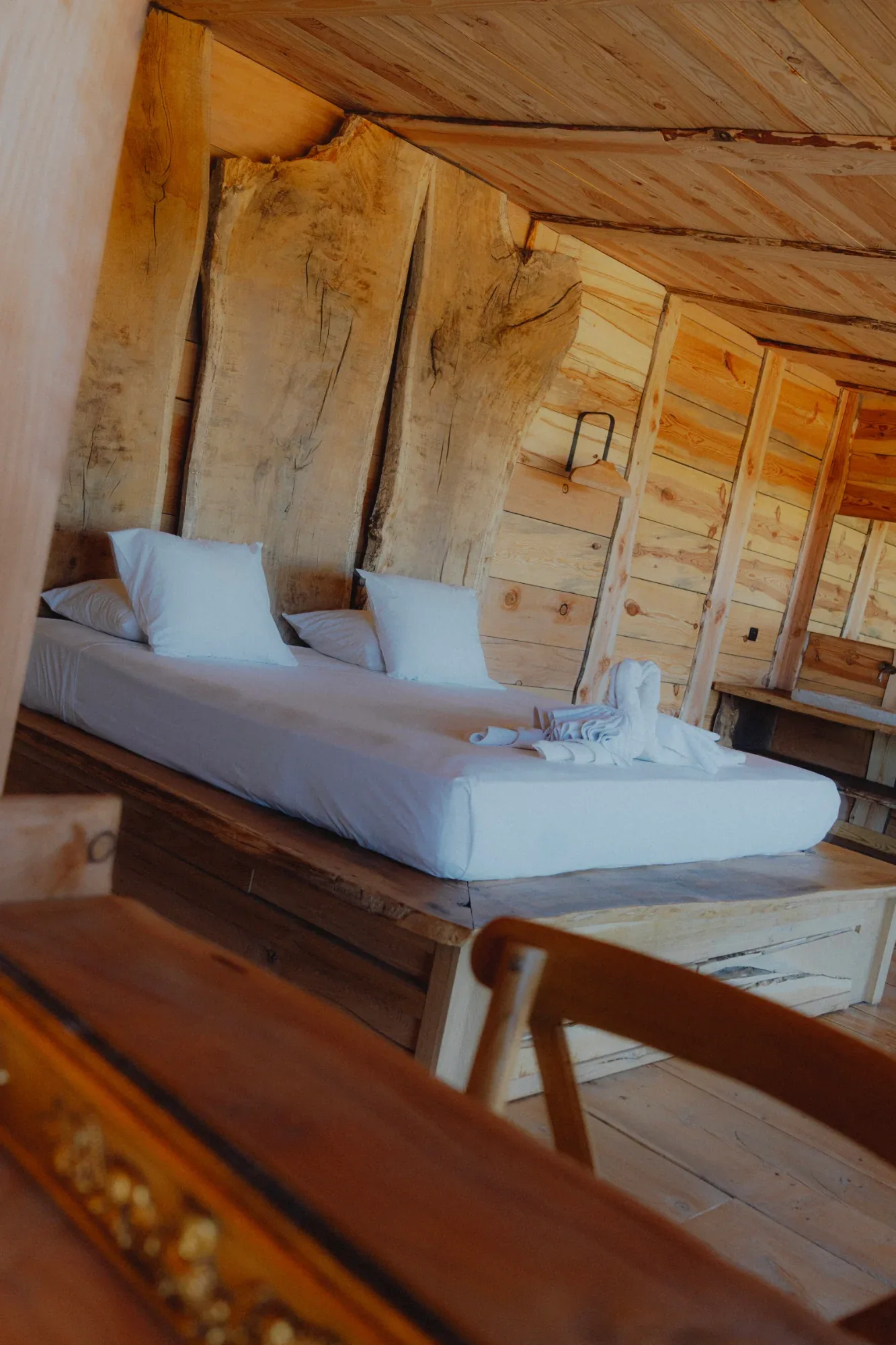 Suite bedroom with raw wood walls, accommodation on the estate